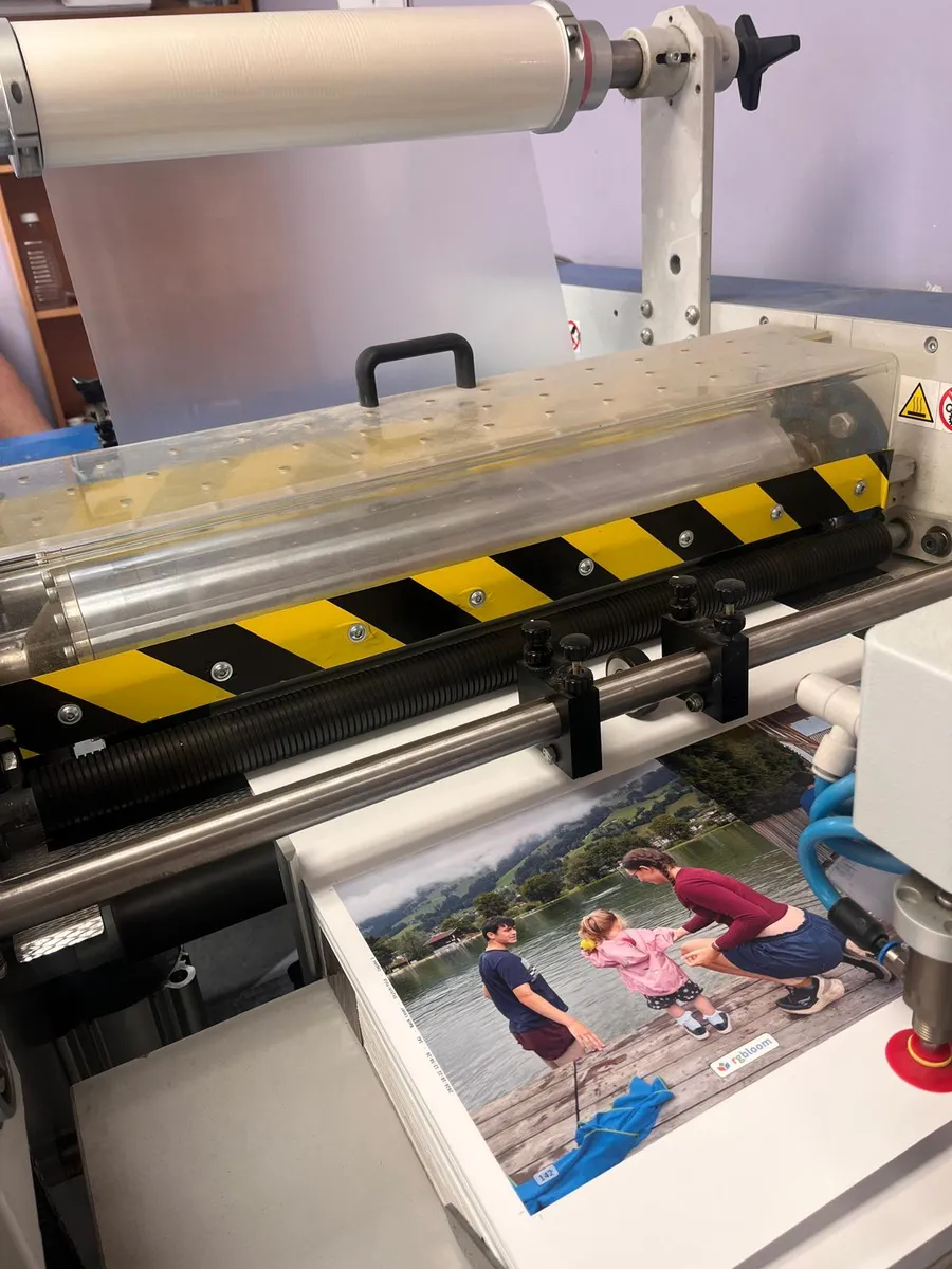 The cover going in under a roll of clear gloss film