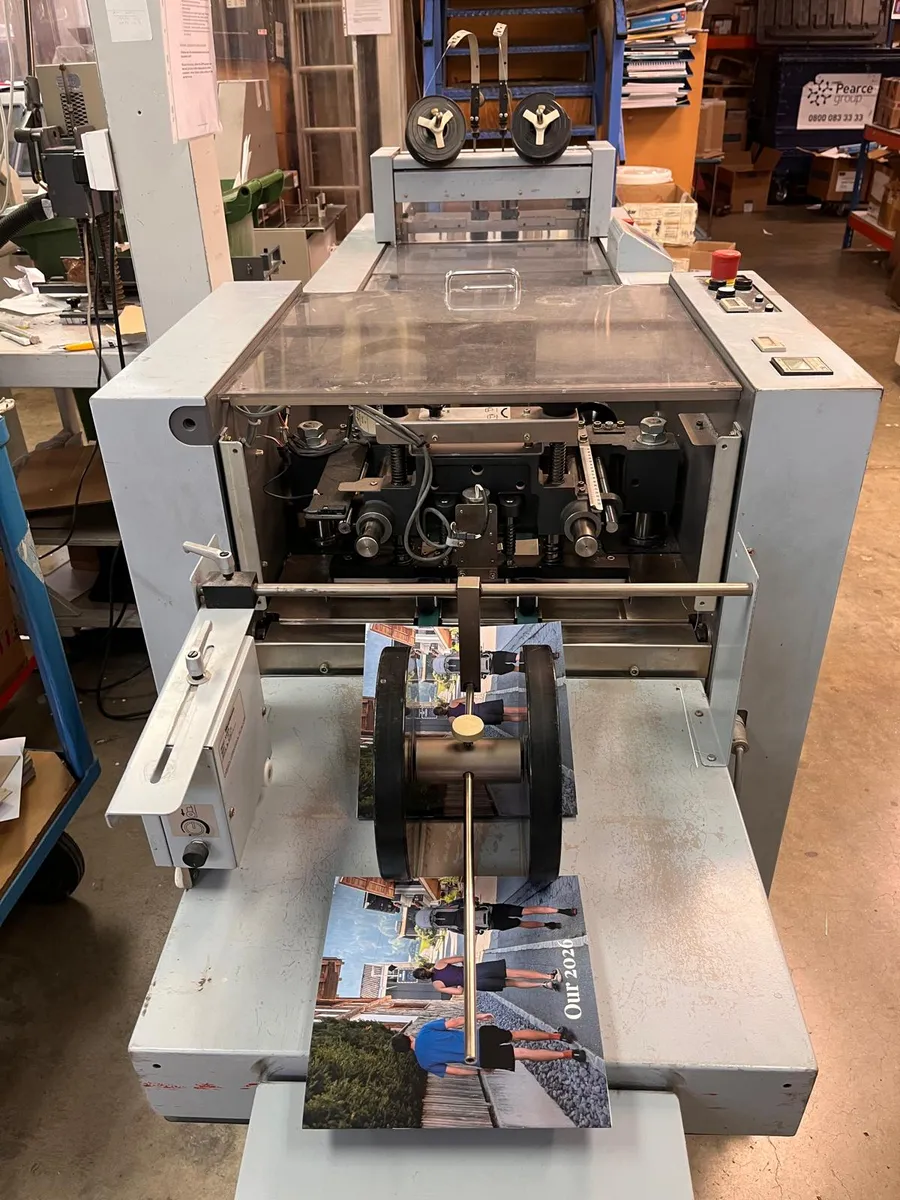 The finished, folded book coming out of the machine