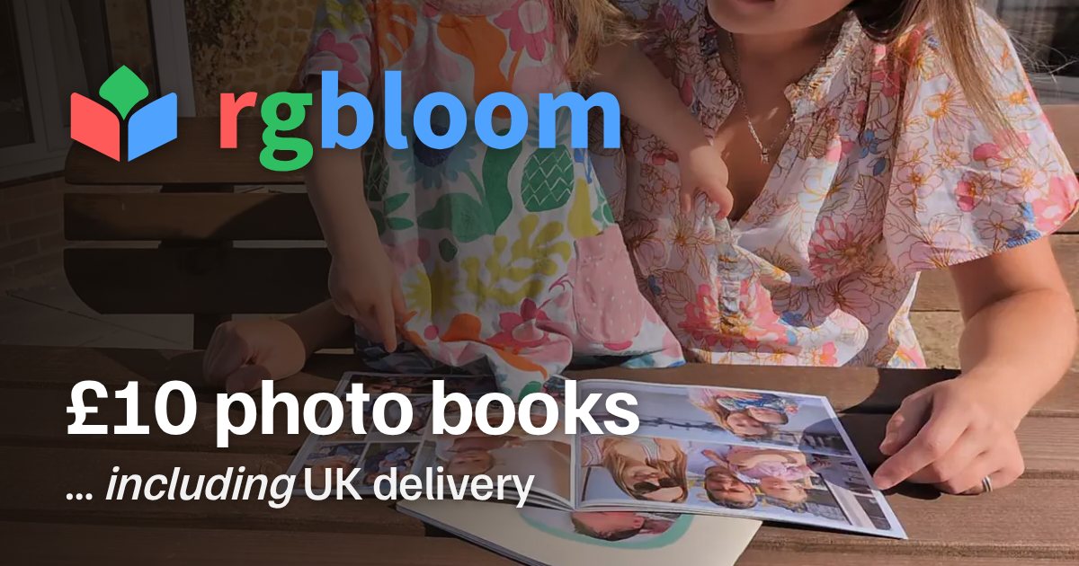 An open RGBloom photo book on a table, a child pointing at a photo in it